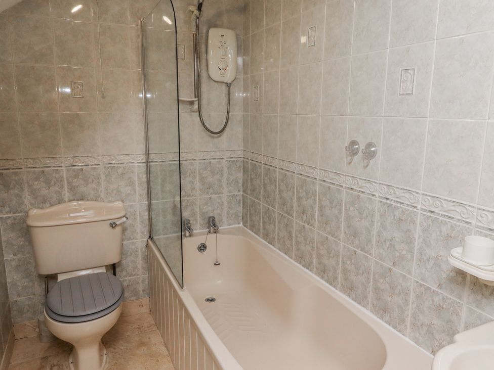 A bathroom with a shower and bathtub at 3 Christon Bank Mews Alnwick