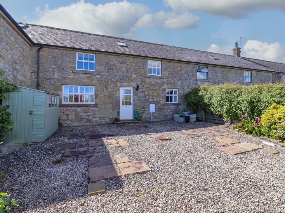 An outdoor area with a stone wall and gravel at 3 Christon Bank Mews in Christon Bank