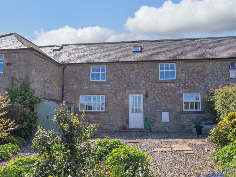 A stone house with a garden and pathway at 3 Christon Bank Mews in Christon Bank