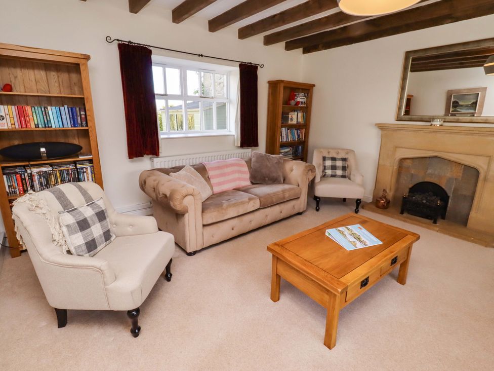 A living room with a bookshelf and a coffee table at 3 Christon Bank Mews in Christon Bank