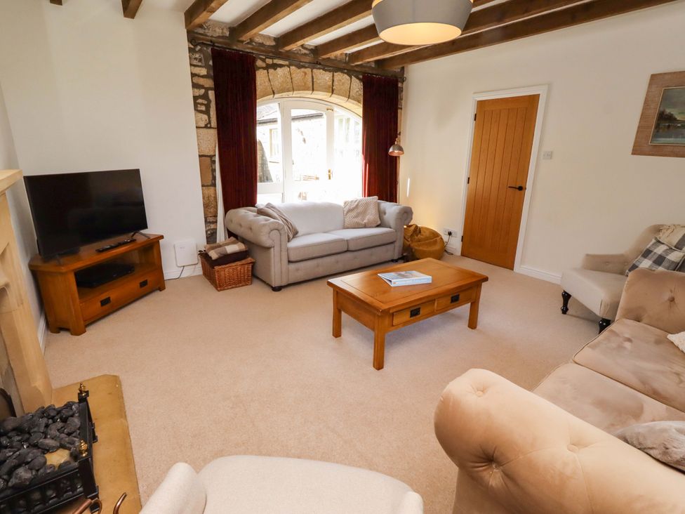 A living room with a sofa a coffee table and a television at 3 Christon Bank Mews Christon Bank