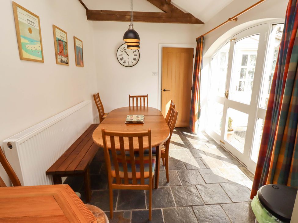 A dining room with a wooden table and chairs at 3 Christon Bank Mews in Christon Bank