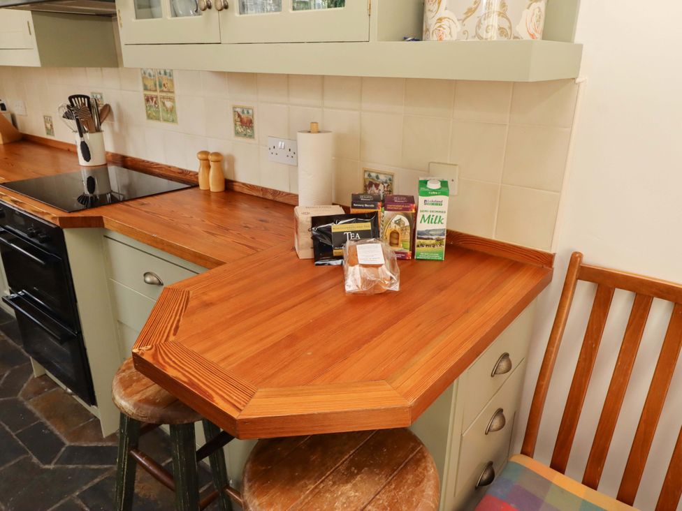 A kitchen with a countertop and stools at 3 Christon Bank Mews in Christon Bank