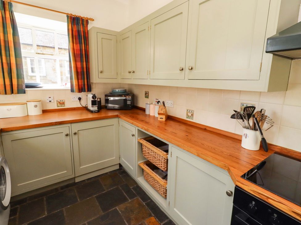 A kitchen with cabinets and countertop at 3 Christon Bank Mews in Christon Bank