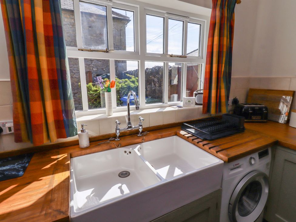 A kitchen with a sink and washing machine at 3 Christon Bank Mews Christon Bank