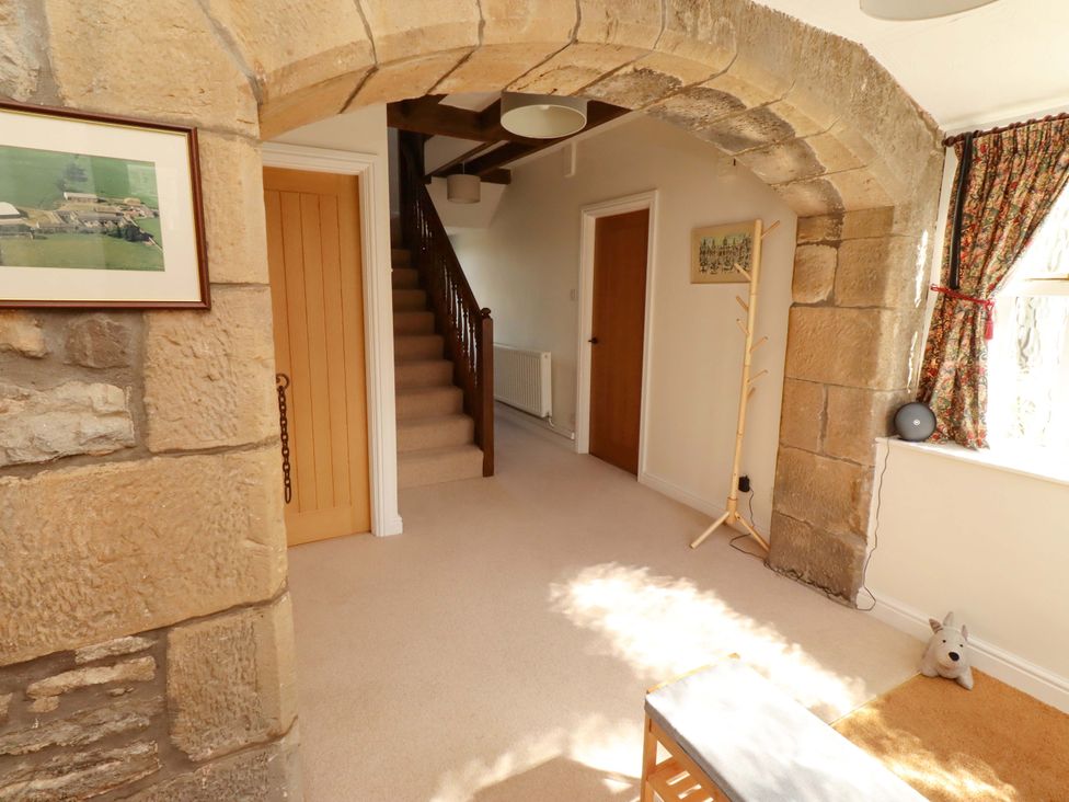 A hallway with a staircase and framed pictures at 3 Christon Bank Mews Christon Bank