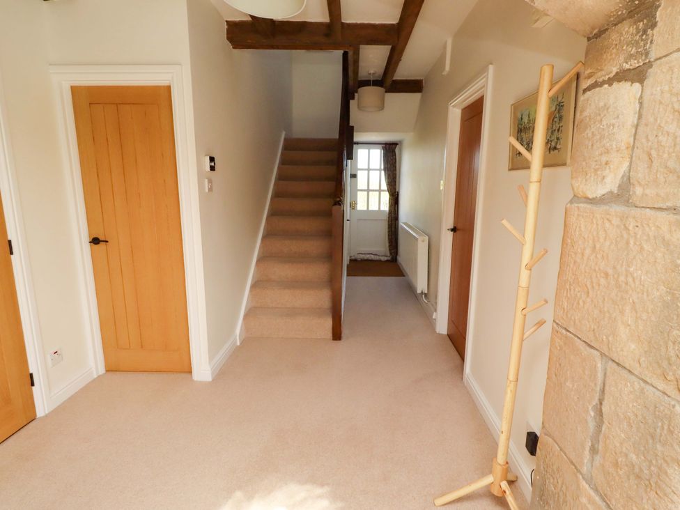 A hallway with a staircase and a coat rack at 3 Christon Bank Mews in Christon Bank