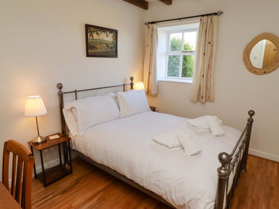 A bedroom with a bed and lamp at 3 Christon Bank Mews in Christon Bank