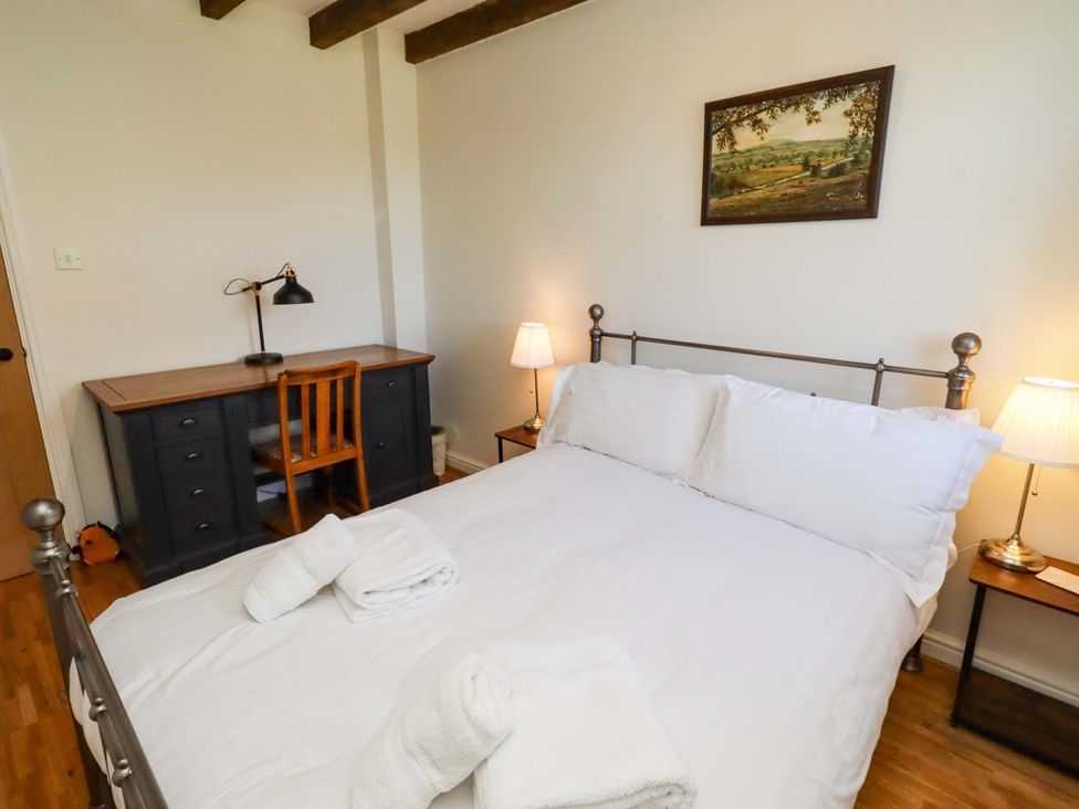 A bedroom with a bed and desk at 3 Christon Bank Mews in Christon Bank