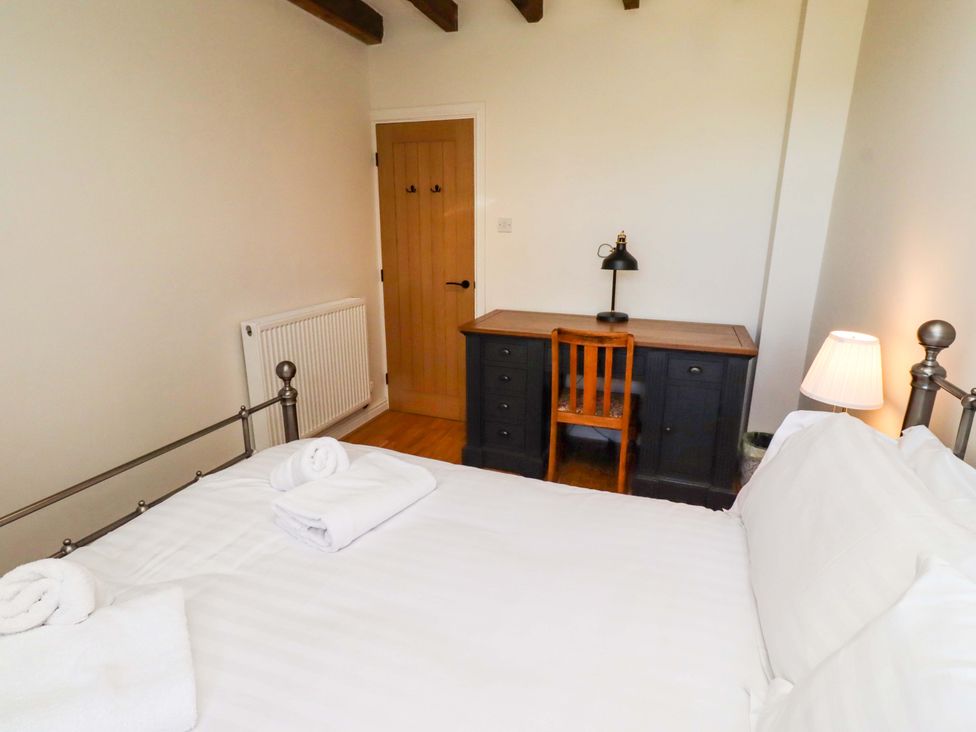 A bedroom with a bed and desk at 3 Christon Bank Mews in Christon Bank