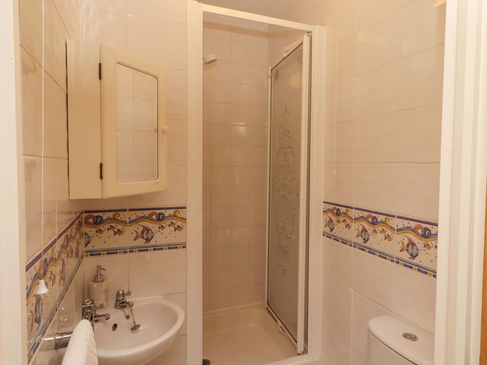A bathroom with a shower and sink at 3 Christon Bank Mews, Christon Bank