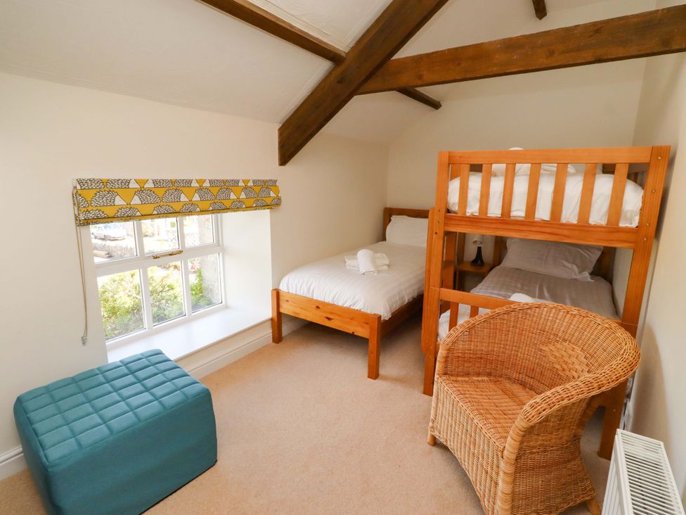 A bedroom with a bunk bed and single bed at 3 Christon Bank Mews in Christon Bank