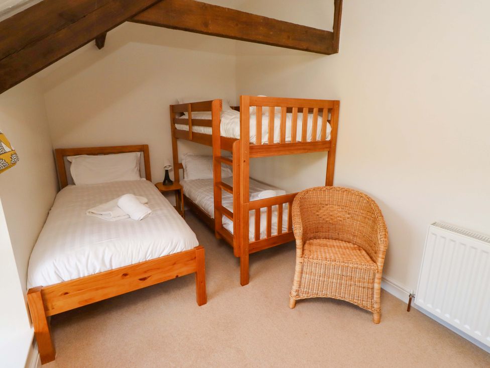 A bedroom with a single bed and a bunk bed at 3 Christon Bank Mews in Christon Bank