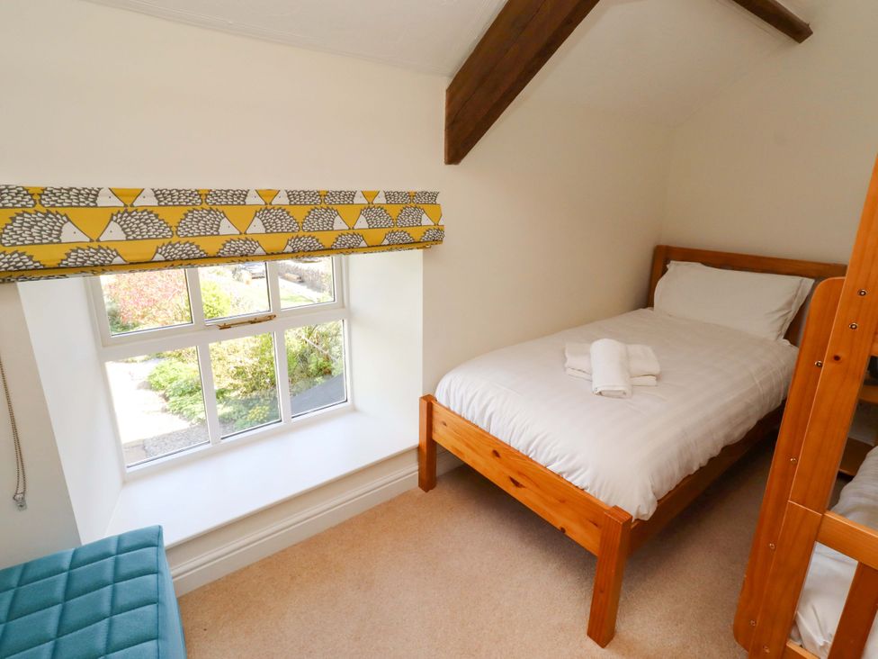 A bedroom with a bed and a bunk bed at 3 Christon Bank Mews in Christon Bank