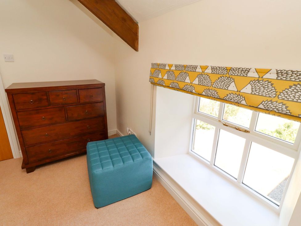A bedroom with a chest of drawers and an ottoman at 3 Christon Bank Mews Christon Bank