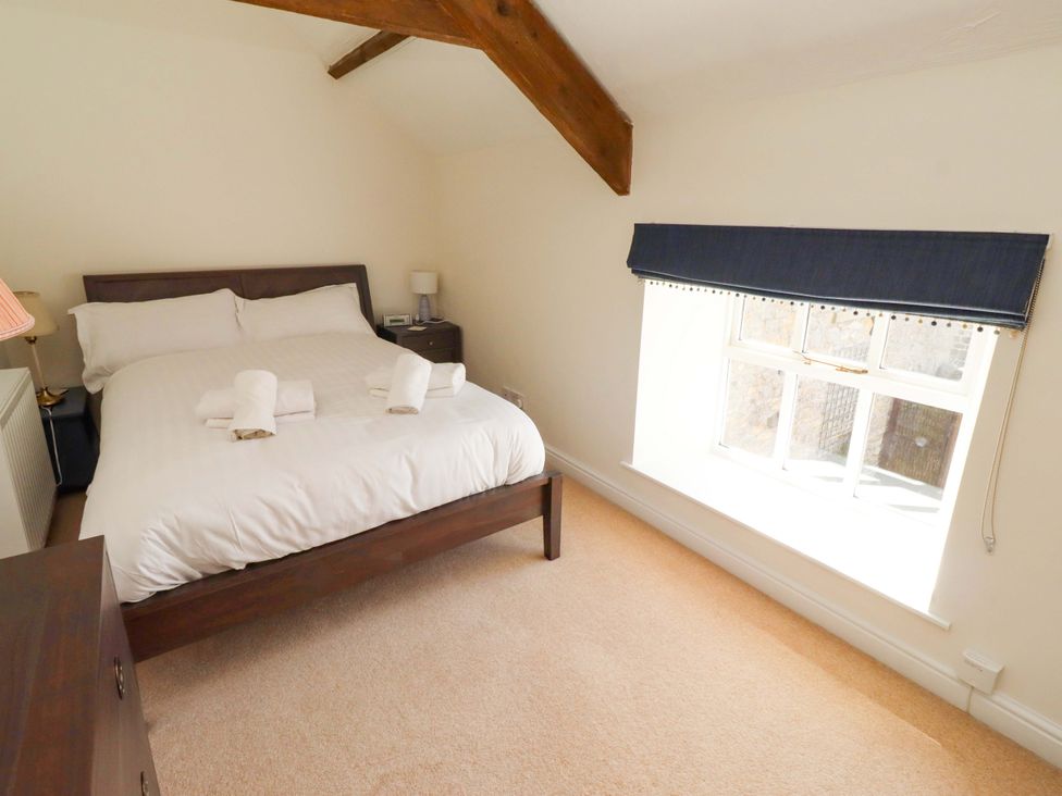 A bedroom with a bed and a window at 3 Christon Bank Mews in Christon Bank