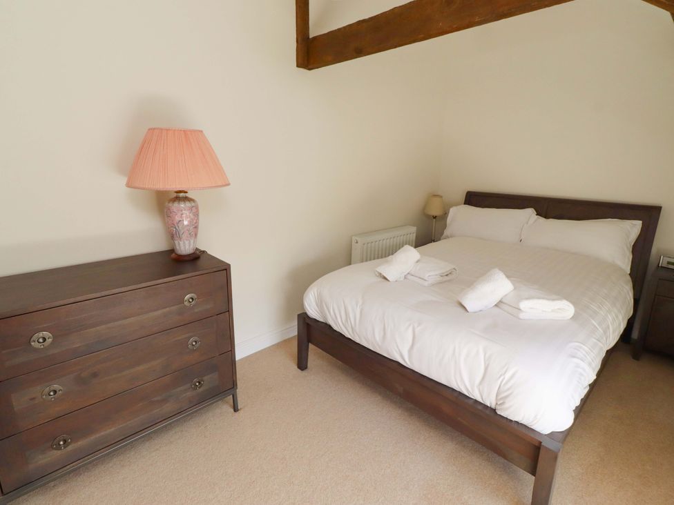 A bedroom with a bed and dresser at 3 Christon Bank Mews in Christon Bank