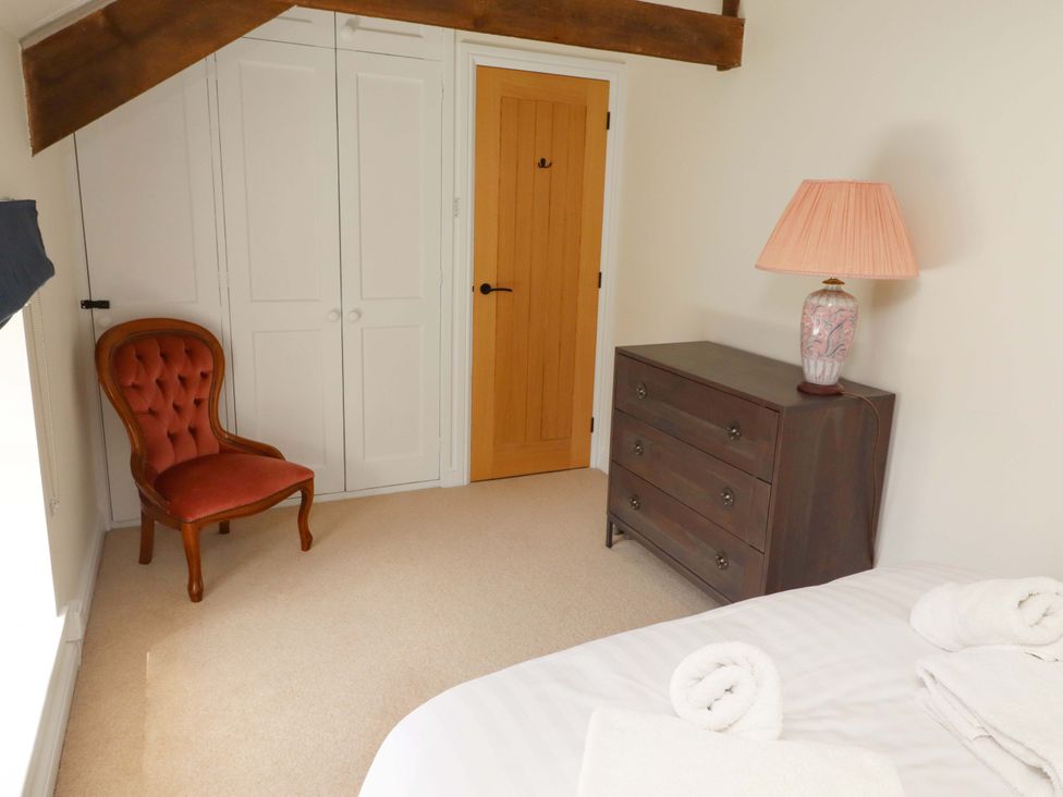 A bedroom with a dresser and chair at 3 Christon Bank Mews in Christon Bank