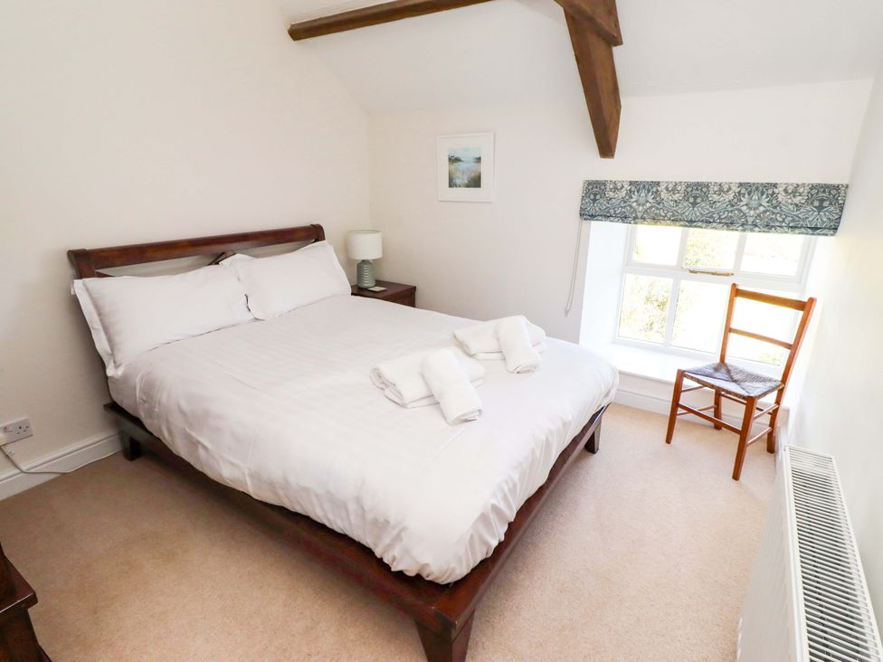 A bedroom with a bed and chair at 3 Christon Bank Mews, Christon Bank