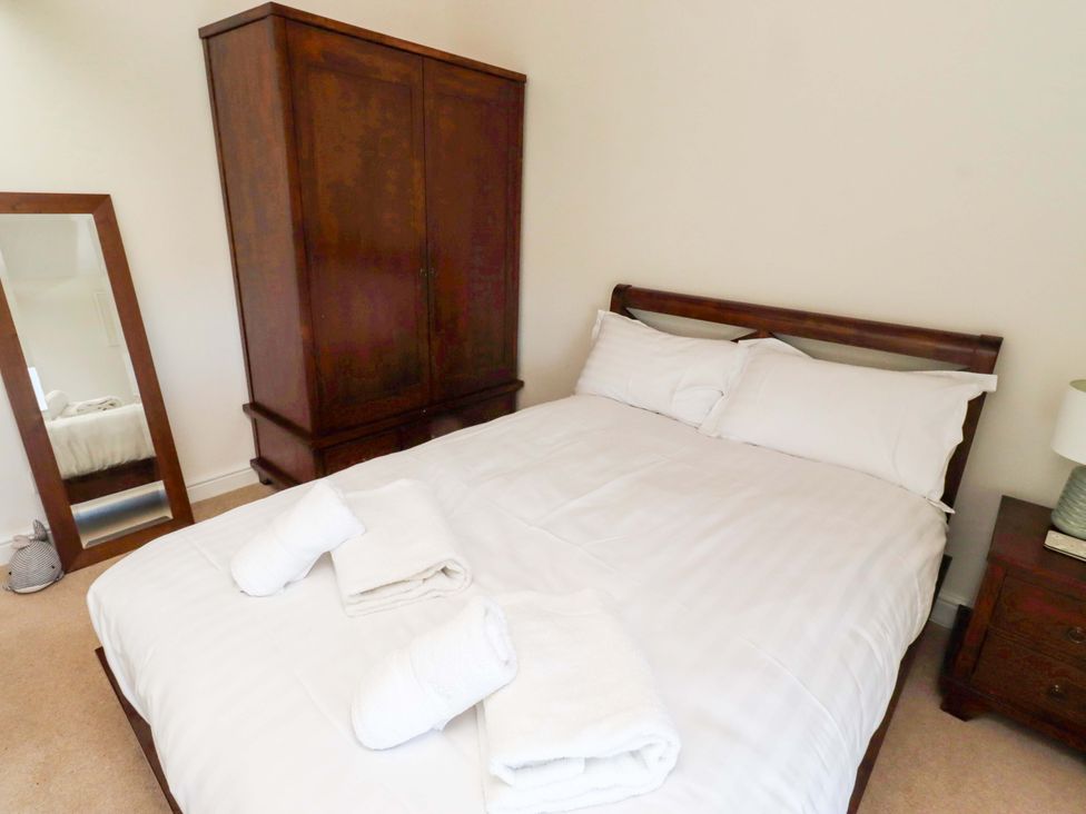 A bedroom with a bed and wardrobe at 3 Christon Bank Mews in Christon Bank