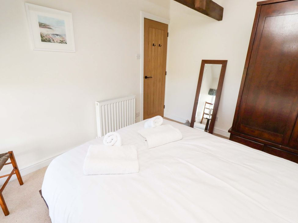 A bedroom with a bed and towels at 3 Christon Bank Mews in Christon Bank