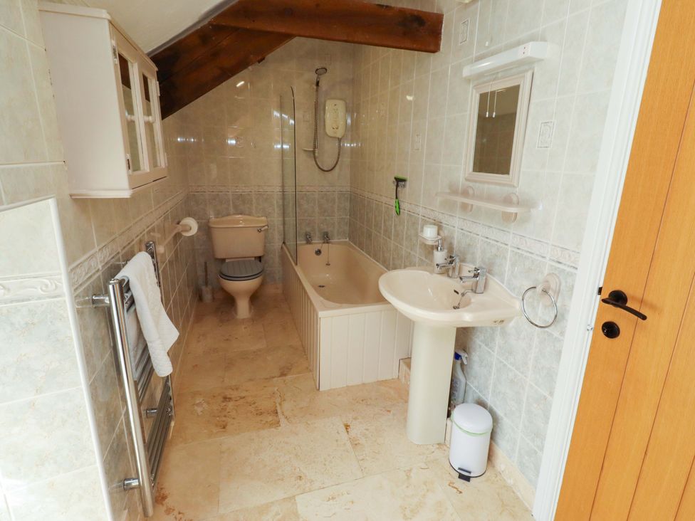 A bathroom with a bathtub, toilet, and sink at 3 Christon Bank Mews in Christon Bank