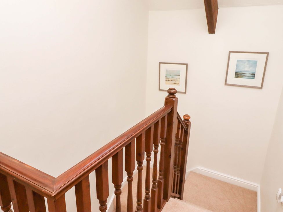 A staircase with wooden handrail and framed pictures at 3 Christon Bank Mews in Christon Bank