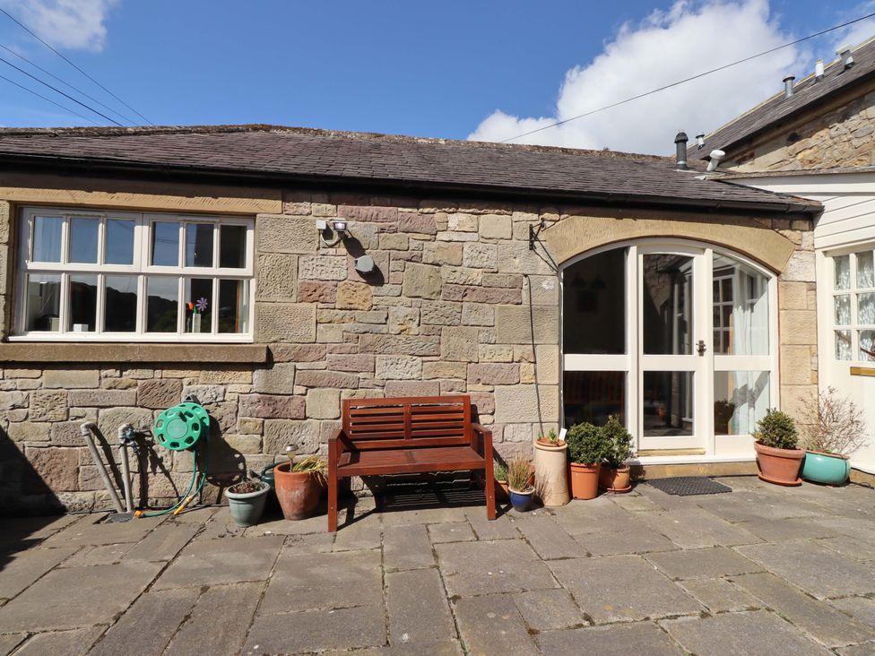 An outdoor area with a bench and plants at 3 Christon Bank Mews in Christon Bank