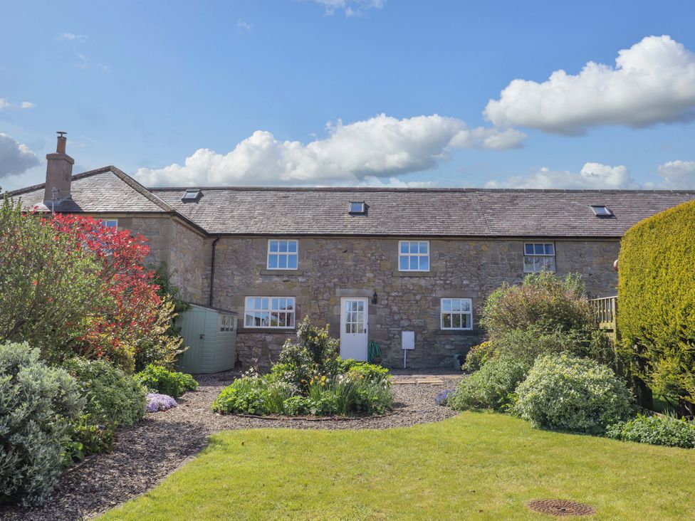 An outdoor view of a stone building with a garden at 3 Christon Bank Mews in Christon Bank