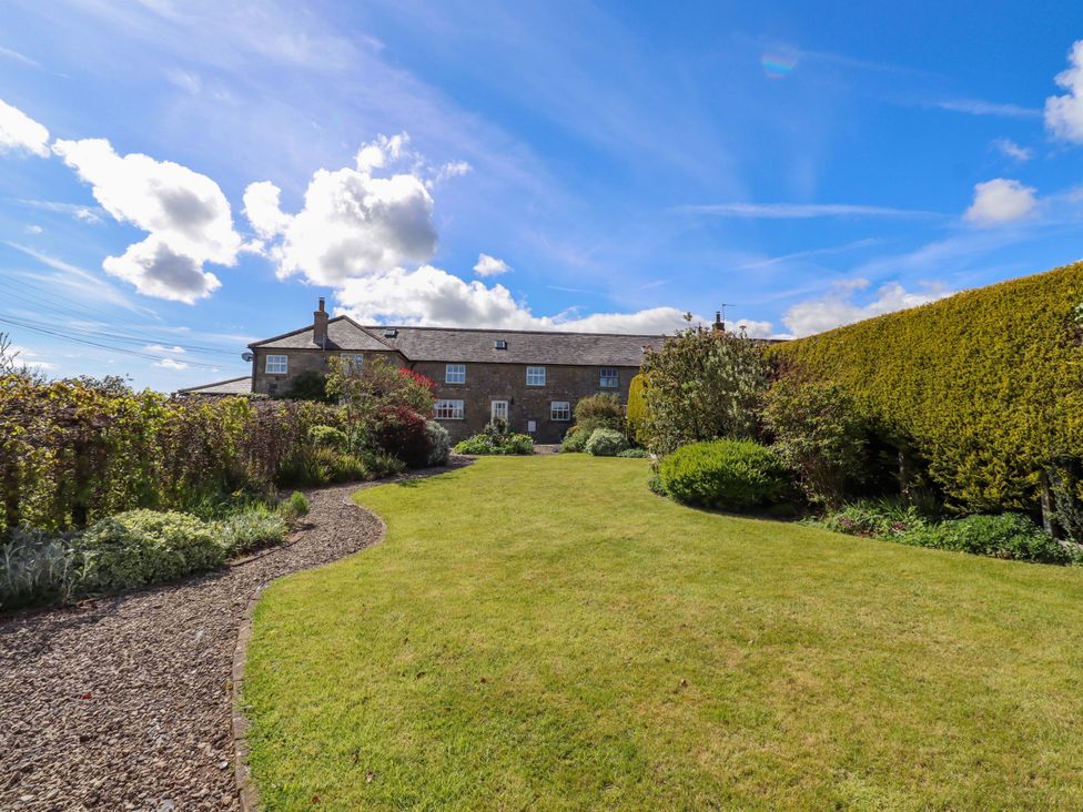 A garden with a house and hedges at 3 Christon Bank Mews in Christon Bank