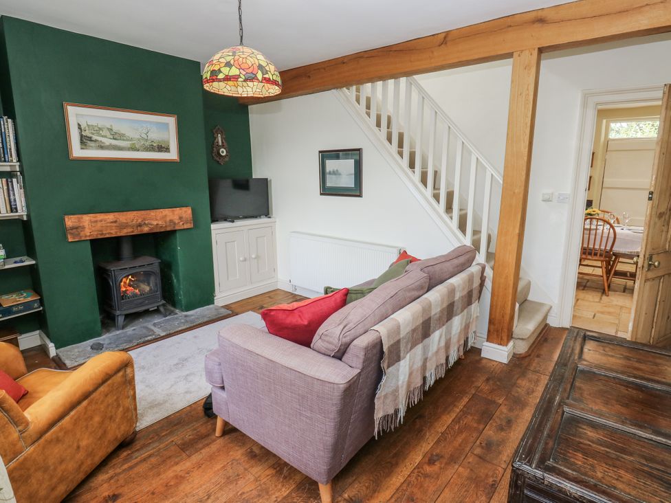 A living room with a fireplace and sofa at Centenary Cottage Skipton