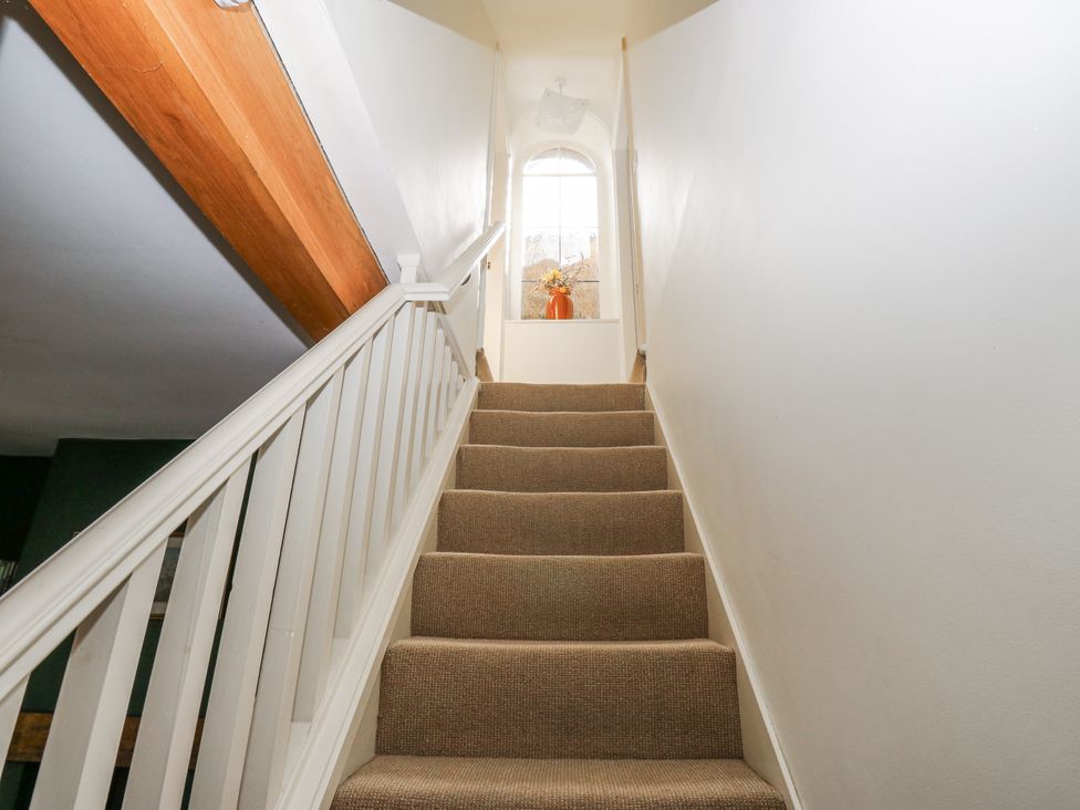 A staircase with a handrail and window at Centenary Cottage in Skipton
