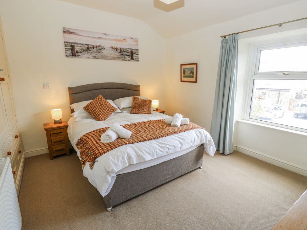 A bedroom with a bed and bedside tables at Centenary Cottage in Skipton