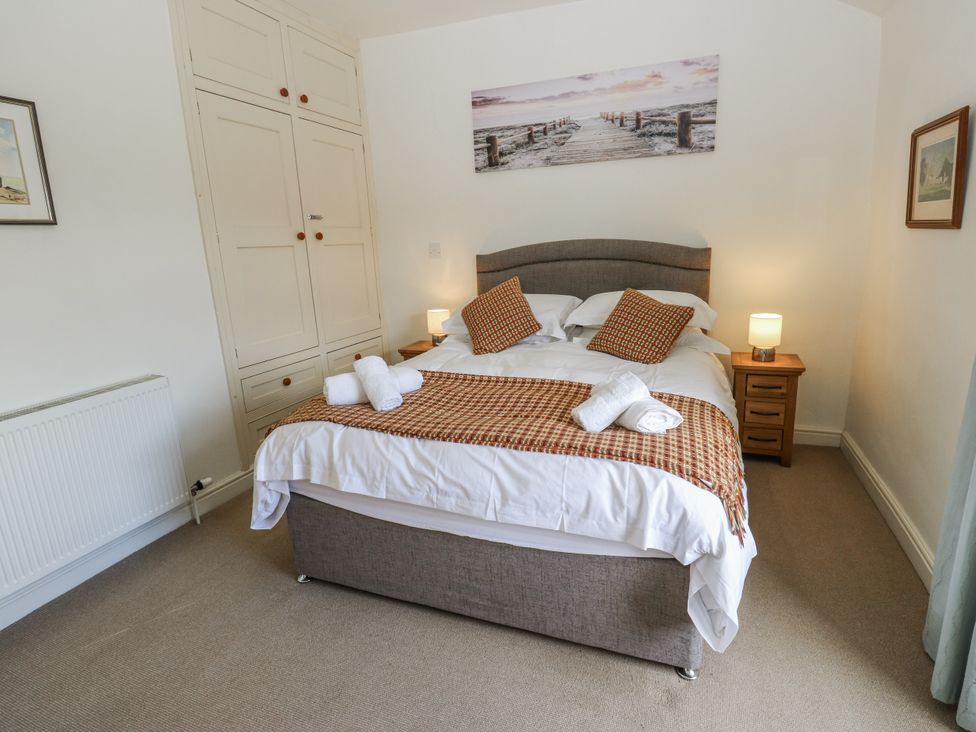 A bedroom with a bed and bedside table at Centenary Cottage in Skipton