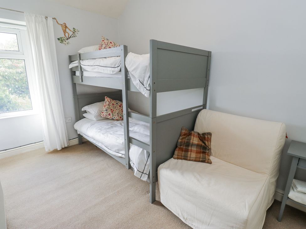 A bedroom with bunk beds and a sofa at Centenary Cottage in Skipton