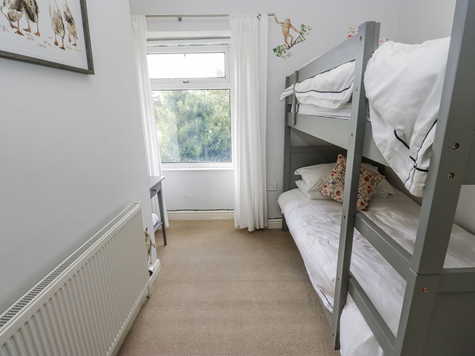 A bedroom with a bunk bed and a window at Centenary Cottage in Skipton