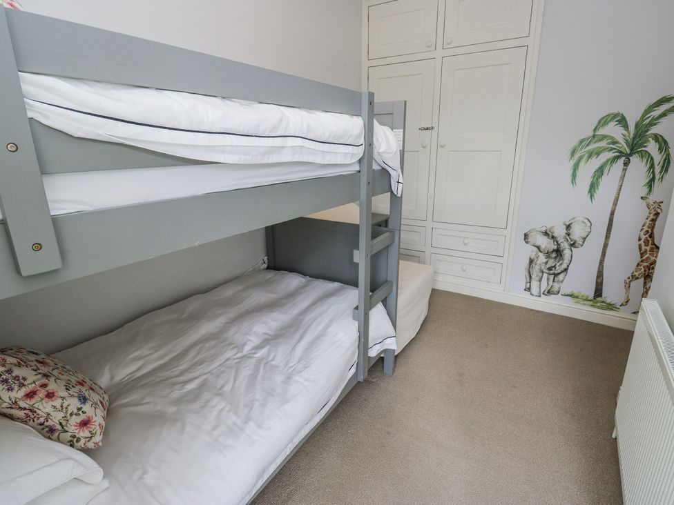 A bedroom with a bunk bed and wardrobe at Centenary Cottage in Skipton