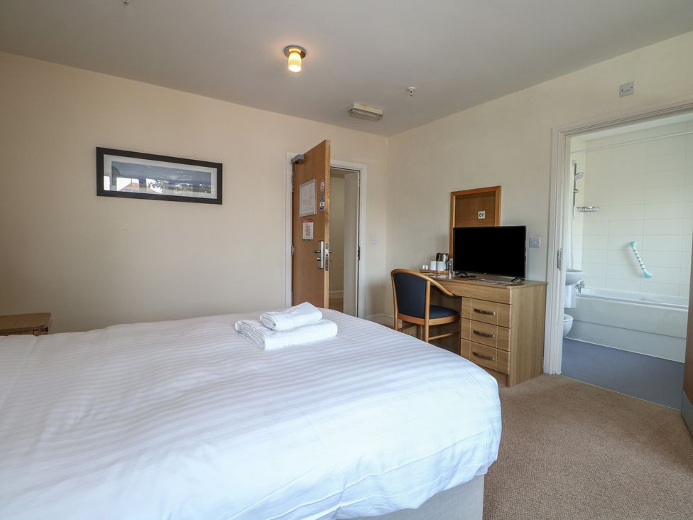 A bedroom with a bed and desk at Bedroom 18 in Littlehampton