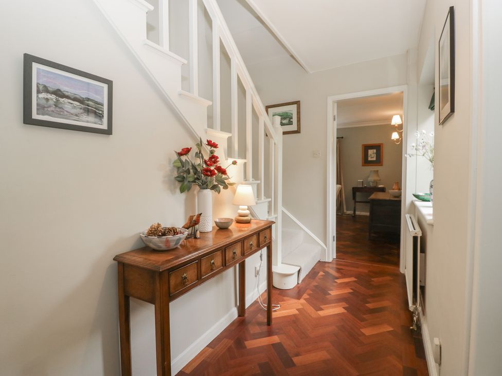 A hallway with a staircase and a console table at St. Marys House in Church Westcote near Bledington