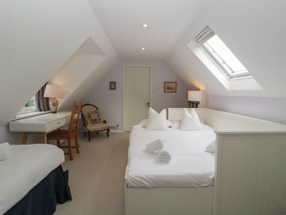 A bedroom with a double bed and writing desk at St. Marys House Church Westcote near Bledington