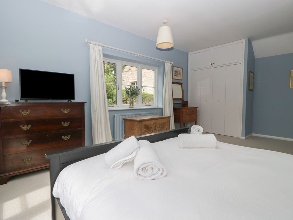 A bedroom with a bed and television at St. Marys House Church Westcote near Bledington