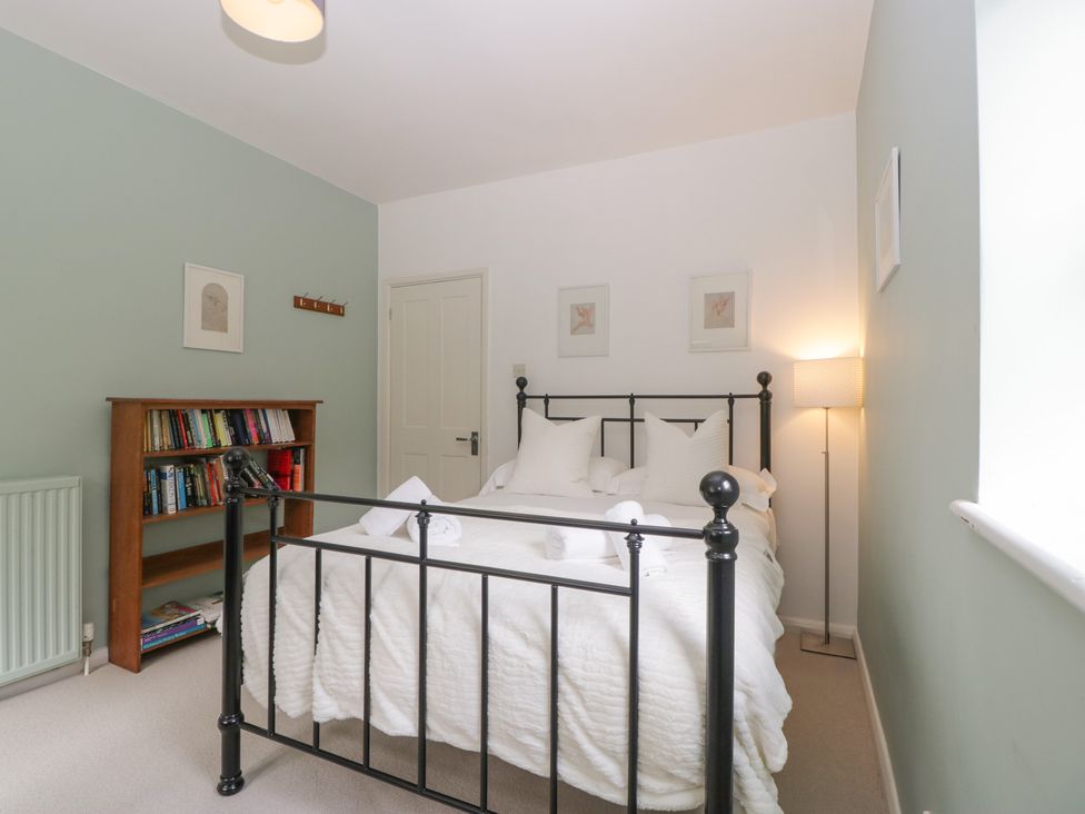 A bedroom with a bed and bookshelf at St. Marys House, Church Westcote near Bledington