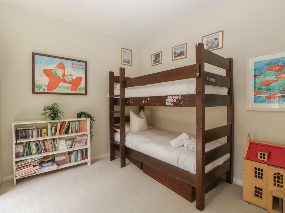 A bedroom with a bunk bed and bookshelf at St. Marys House Church Westcote near Bledington