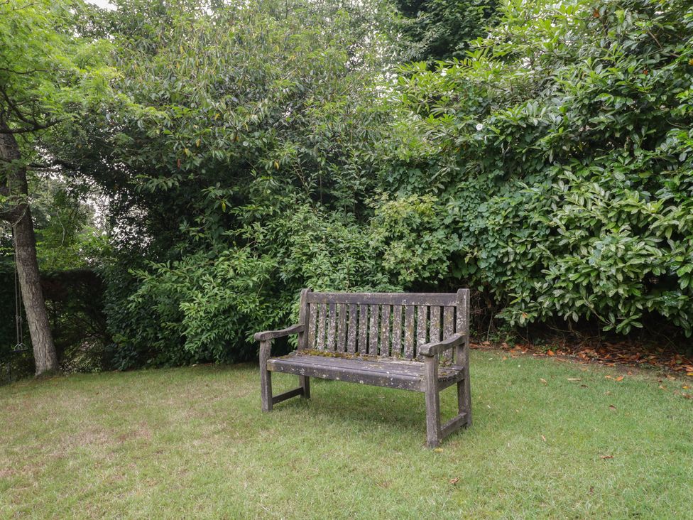 A bench in a garden surrounded by greenery at St. Marys House Church Westcote near Bledington