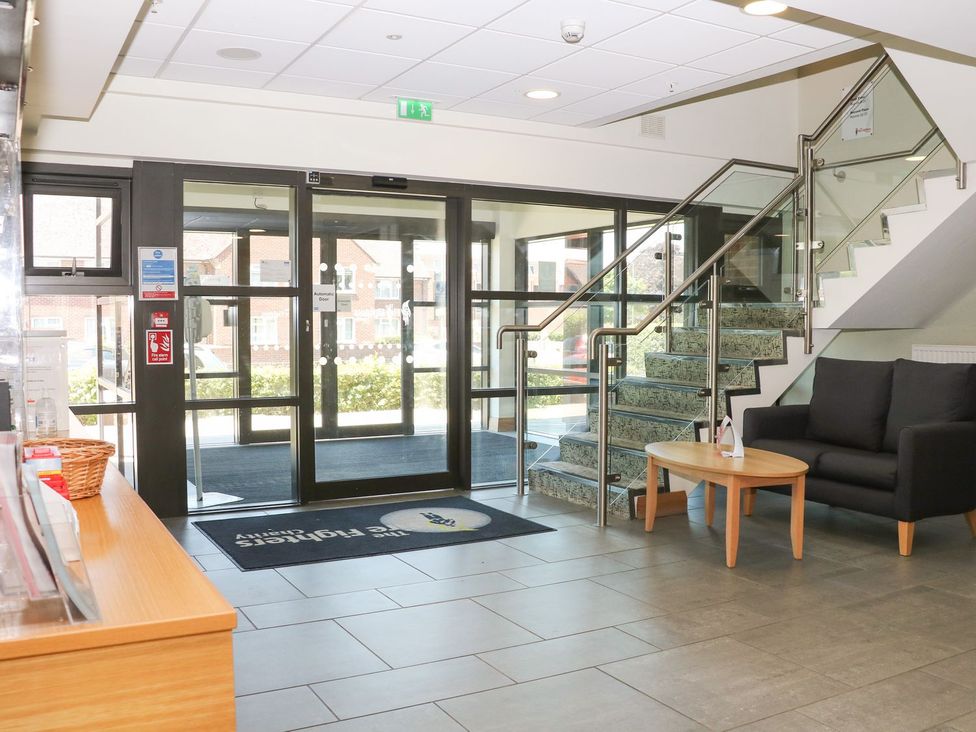A lobby with a reception desk and seating area at The Foyleside Community in Littlehampton