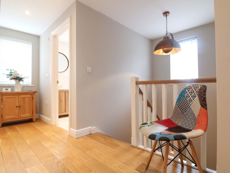 A hallway with a chair and wooden cabinet at Farm View House in Somerby