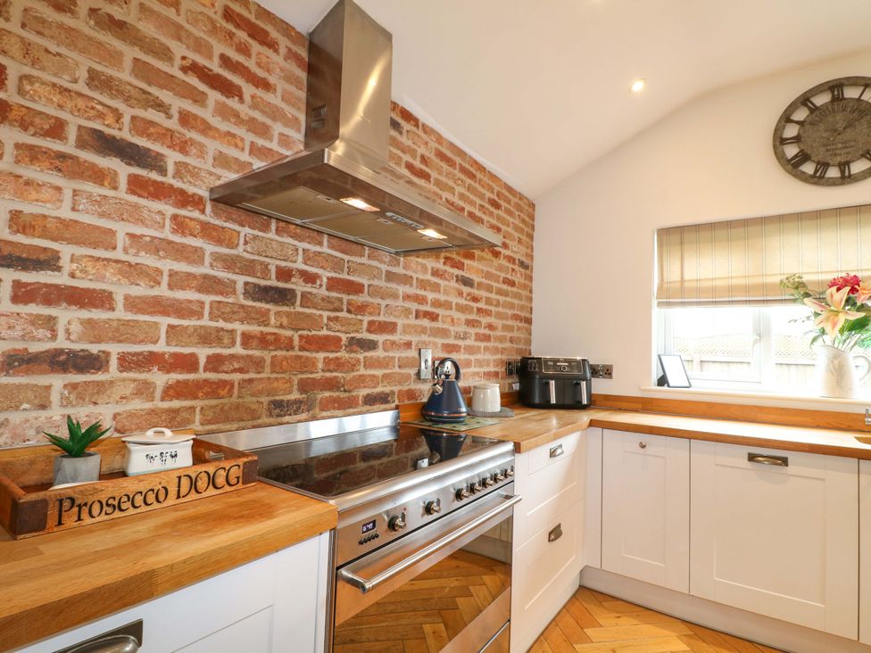 A kitchen with a gas stove and brick wall at Farm View House in Somerby