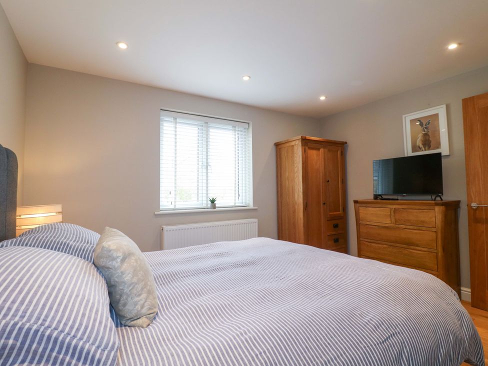 A bedroom with a bed and wardrobe at Farm View House in Somerby