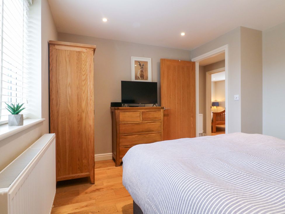 A bedroom with a bed and wooden furniture at Farm View House Somerby
