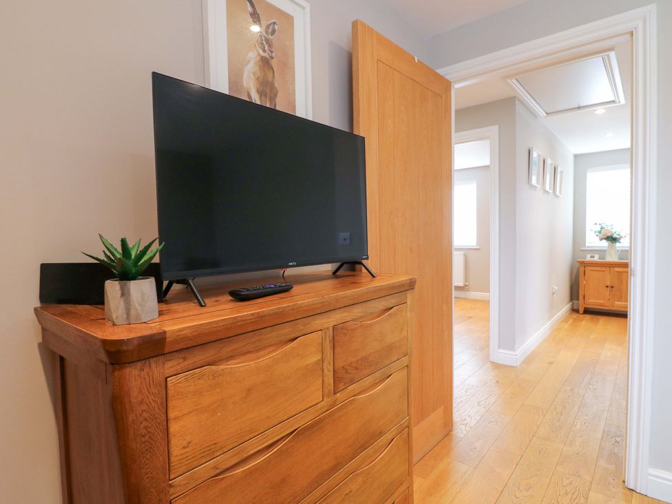 A hallway with a television and drawer unit at Farm View House in Somerby